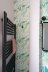 Liznylon_bathroom_pink_and_green_wallpaper_and_black_radiator_and_hook